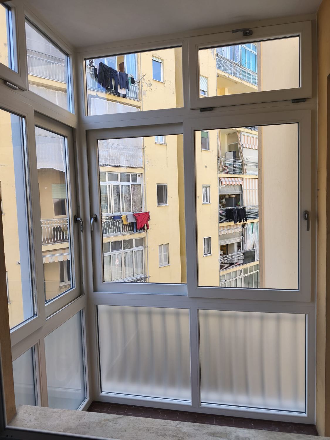 Balcone chiuso con serramenti bianchi