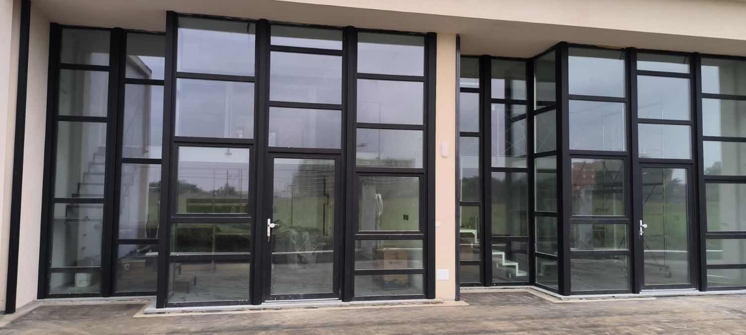 Facciata vetrata con profili neri e porte